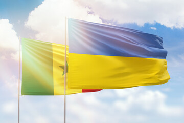 Sunny blue sky and flags of ukraine and senegal