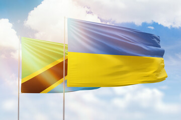 Sunny blue sky and flags of ukraine and tanzania