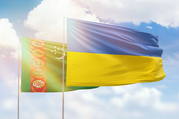 Sunny blue sky and flags of ukraine and turkmenistan