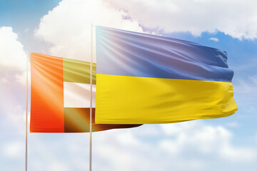 Sunny blue sky and flags of ukraine and uae