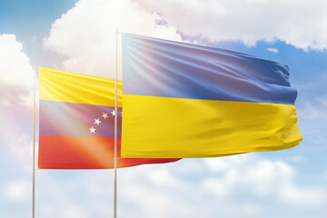 Sunny blue sky and flags of ukraine and venezuela