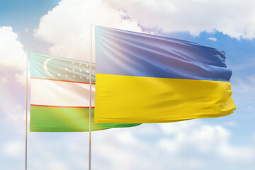 Sunny blue sky and flags of ukraine and uzbekistan