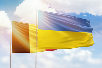 Sunny blue sky and flags of ukraine and belgium