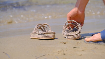 A female and slippers on the beach. Female foot. Slippers on the beach. female and slippers on the...