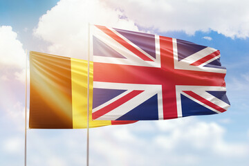 Sunny blue sky and flags of united kingdom and belgium