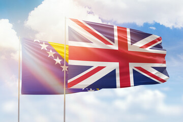 Sunny blue sky and flags of united kingdom and bosnia