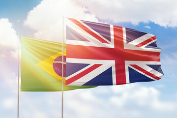 Sunny blue sky and flags of united kingdom and brazil