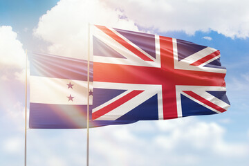 Sunny blue sky and flags of united kingdom and honduras