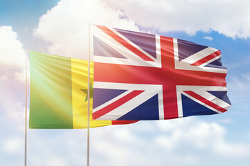 Sunny blue sky and flags of united kingdom and senegal