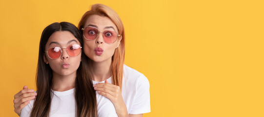 Mother and daughter child banner, copy space, isolated background. happy family portrait of woman mother and kid in glasses blow kiss, togetherness.