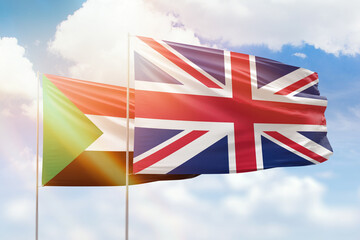 Sunny blue sky and flags of united kingdom and sudan