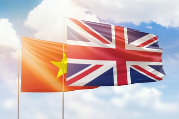Sunny blue sky and flags of united kingdom and vietnam