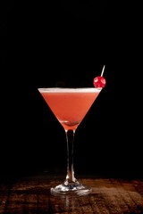 front view strawberry martini cocktail glass with cherry and foam dark background over wooden table