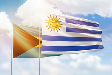 Sunny blue sky and flags of uruguay and bahamas