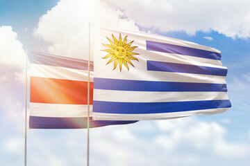 Sunny blue sky and flags of uruguay and costa rica