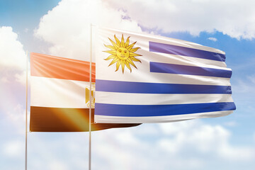 Fototapeta premium Sunny blue sky and flags of uruguay and egypt