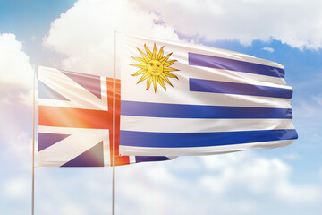 Sunny blue sky and flags of uruguay and great britain