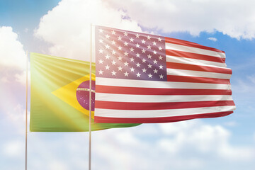 Sunny blue sky and flags of united states of america and brazil