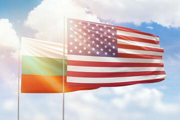 Sunny blue sky and flags of united states of america and bulgaria