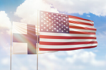 Sunny blue sky and flags of united states of america and finland