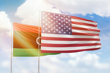 Sunny blue sky and flags of united states of america and libya