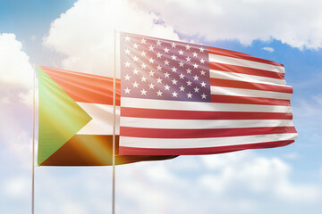Sunny blue sky and flags of united states of america and sudan