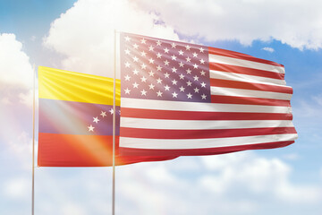Sunny blue sky and flags of united states of america and venezuela