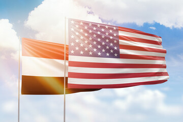 Sunny blue sky and flags of united states of america and yemen