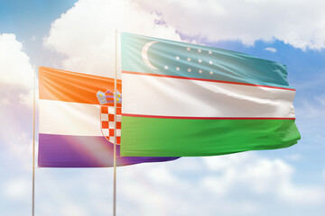 Sunny blue sky and flags of uzbekistan and croatia