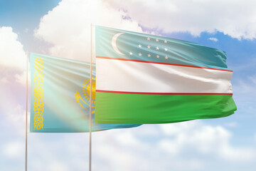 Sunny blue sky and flags of uzbekistan and kazakhstan - obrazy, fototapety, plakaty