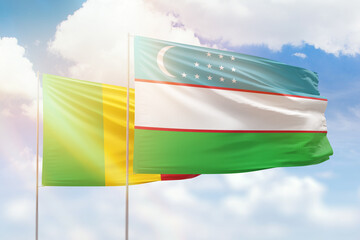 Sunny blue sky and flags of uzbekistan and mali