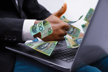 100 Australian dollar notes coming out of laptop with Business man giving thumbs up, Financial...