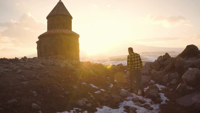 Man is walking in front of the Saint Gregory church on sunset at Ani ancient city Kars Turkey