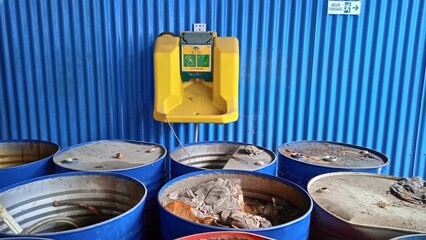 Eye wash device that mounted on a blue wall. That place is hazardous waste storage