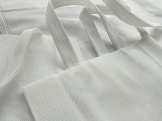 white non-woven fabric tote bag. collections made of non-woven fabrics. pile of textured and...
