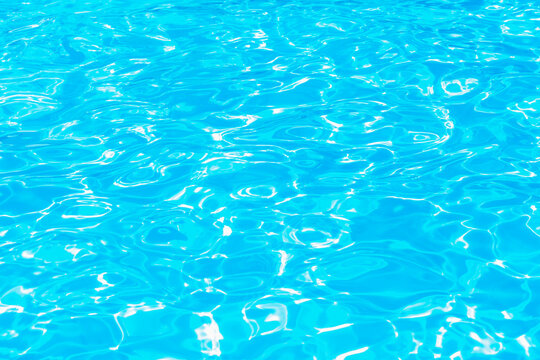 Swimming pool water surface with sparkling light reflections
