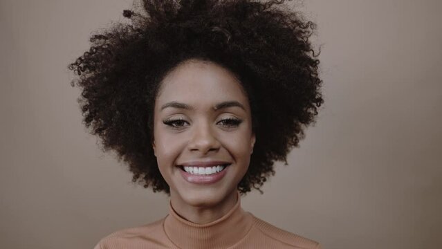 Closeup of a smiling young Latin afro woman. Joy, positive and love. Beautiful african-style hair. Cinematic 4K