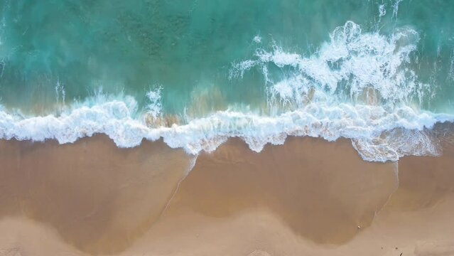 Aerial video beautiful closeup shot beach and seawater on wave on sand in sunset time (Top-view) nature and travel concept video.