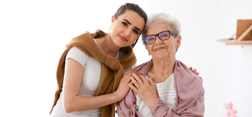 Portrait of caregiver with senior woman in nursing home