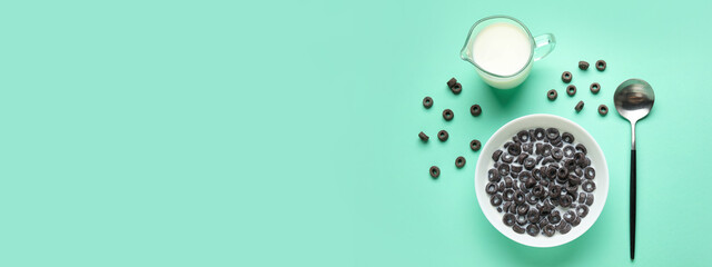 Composition with tasty cereal rings and milk on turquoise background with space for text