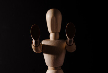 Wooden mannequin making a stop sign