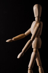 Wooden mannequin walking with black background