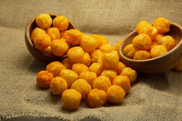 Cheese flavoured Puffs or balls closeup over gunny sack background