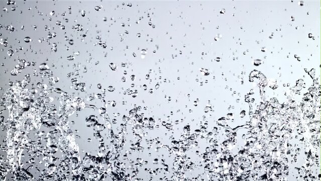 Water with splashes rises up and falls. On a blue background. Filmed is slow motion 1000 fps.