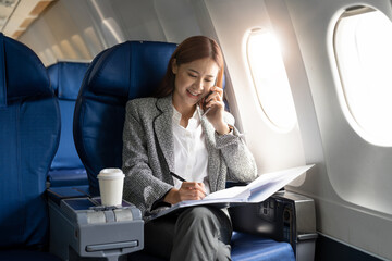 Business young asian woman talking on phone during working for paperwork financial report on...