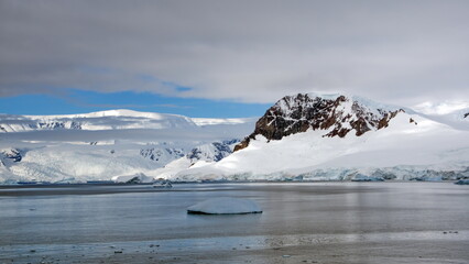 Iceberg floating in front of snow covered mountains at Portal Point, Antarctica