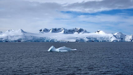 Iceberg floating in front of snow covered mountains at Portal Point, Antarctica
