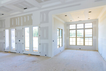 In preparation for painting a newly house, finishing putty is being applied to an empty apartment