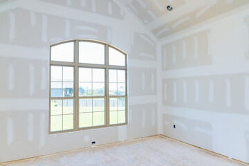 Fototapeta premium An empty apartment room we are finishing the walls with putty a new house under construction