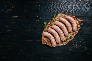 raw sausages with spices and rosemary on cutting board. Cooking ingredients. Natural healthy food concept. top view © Надія Коваль